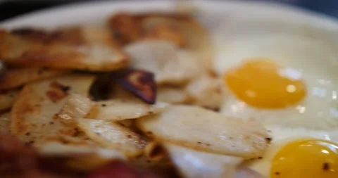 Fried eggs and sliced potato in close up for a tasty breakfast Stock Footage 151499165