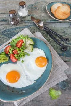 Fried eggs and vegetables Stock Photos