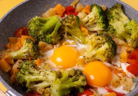 Fried eggs and vegetables Stock Photos