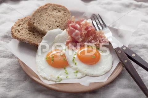 Fried eggs with bacon and bread Stock Photos