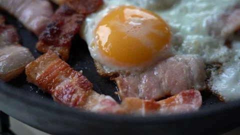 Fried Eggs with Bacon in a Frying Pan. Slices of Toasted Appetizing Bacon and Stock Footage 149300173