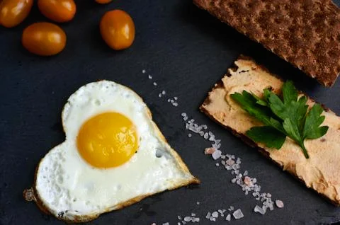 Fried eggs with bread on a black background Stock Photos