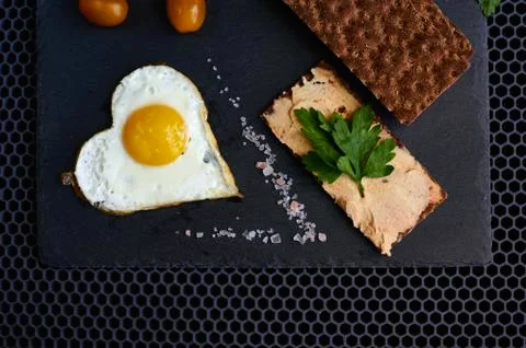 Fried eggs with bread on a black background Stock Photos