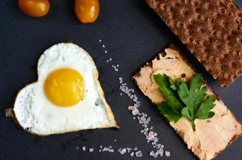 Fried eggs with bread on a black background Stock Photos