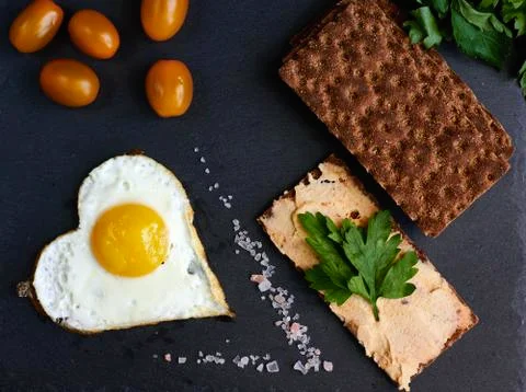 Fried eggs with bread on a black background Stock Photos