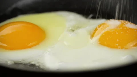 Fried eggs for breakfast. Cooking eggs in frying pan, close up Stock-Footage 244831844