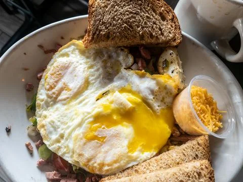 Fried eggs with a broken  yoak with corned beeh hash contianing onions, pep.. Stock Photos