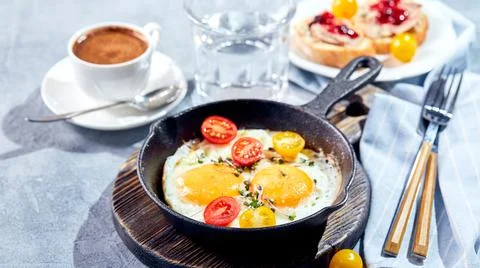 Fried eggs in cast-iron skillets. Sunny morning breakfast concept Stock Photos