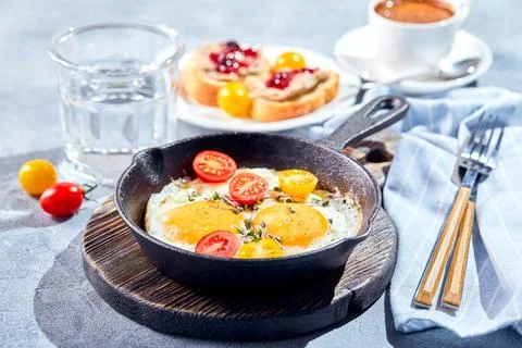 Fried eggs in cast-iron skillets. Sunny morning breakfast concept Stock Photos
