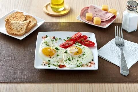 Fried eggs with cherry tomatos, cheese and salami Stock Photos