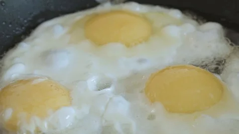 The fried eggs cooked on a pan close up slowmotion Stock Footage 108000278