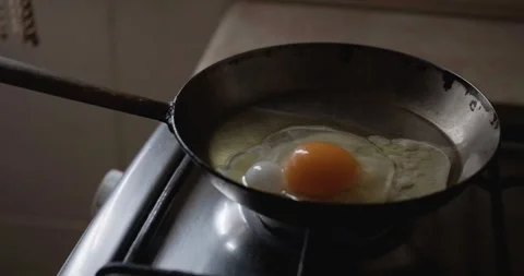 Fried eggs. Cooking fried eggs on a gas stove with natural day light. Stock Footage 246372847