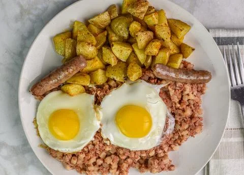 Fried eggs  with corn beef hash and home fries Stock-Fotos