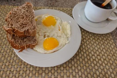 Fried eggs with fresh bread and coffee at breakfast Stock Photos