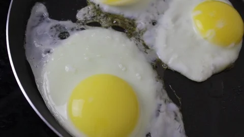 Fried eggs in a frying pan Stock Footage 118667748