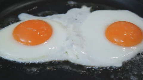 Fried eggs in a frying pan Stock Footage 129325542