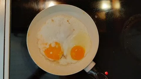 Fried eggs in a frying pan Stock Photos