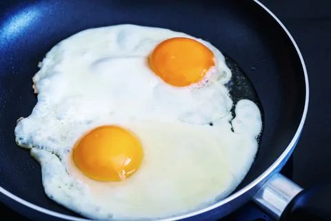 Fried eggs in a frying pan. Stock Photos