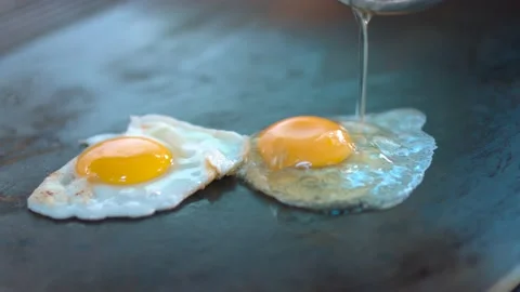 Fried eggs in a hot pan Stock Footage 134466844