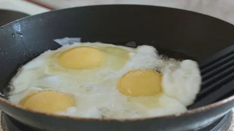 Fried eggs interfere with a spatula in a pan Stock Footage 108000294