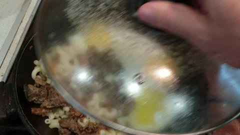 Fried eggs with meat and pasta in a frying pan Vídeo Stock 217963602