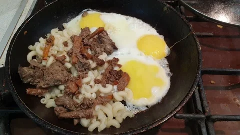 Fried eggs with meat and pasta in a frying pan Vídeos de archivo 217963671