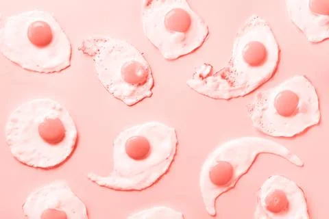 Fried eggs or scrambled eggs pattern on trendy coral color background. Creative Stock Photos