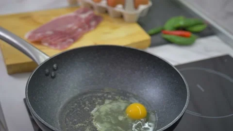 Fried eggs in a pan. Broken egg falls into the frying pan Stock Footage 142134128