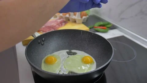 Fried eggs in a pan. Broken egg falls into the frying pan Stock Footage 142134255