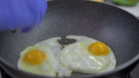 Fried eggs in a pan. Broken egg falls into the frying pan Stock Footage 142134518