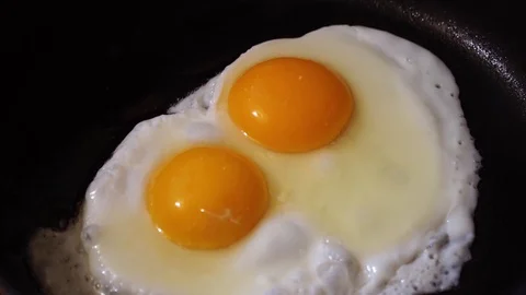 Fried eggs in a pan Stock Footage 128601014