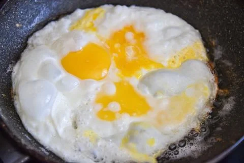 Fried eggs in a pan. Hot appetizing dish Foto stock