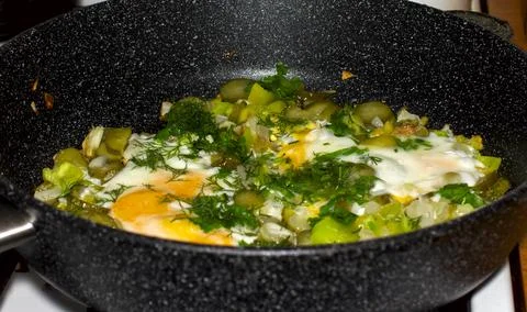 Fried eggs in a pan with vegetables Stock Photos