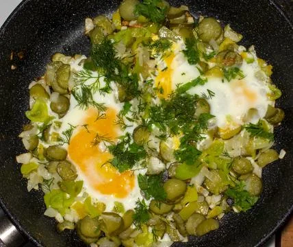Fried eggs in a pan with vegetables Stock Photos