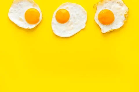Fried eggs pattern on yellow background top view copy space Fotos de archivo