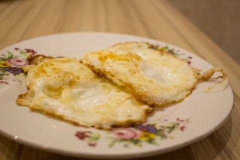 Fried eggs on a plate closeup Stock Photos