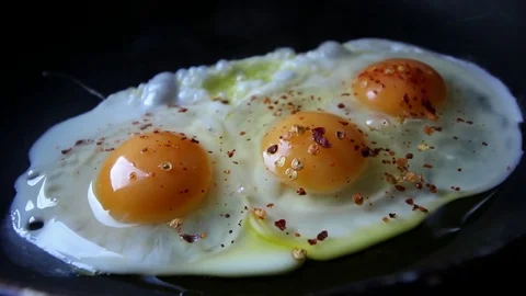 Fried eggs in with red hot chilly pepper Stock Footage 72834993