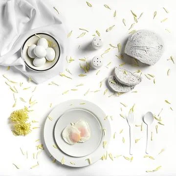 Fried eggs with slices of bread, salt and pepper and flower petals.White conc Stock Photos