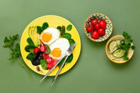 Fried eggs with spinach tomatoes and greens Stock Photos