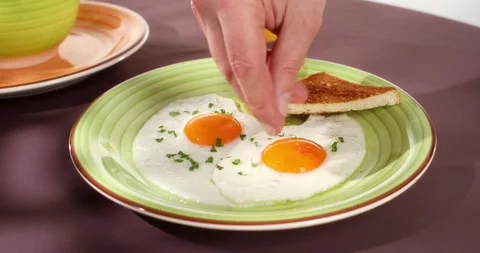 Fried eggs sprinkled with parsley. angle view. close-up. colored background. Stock Footage 244663508