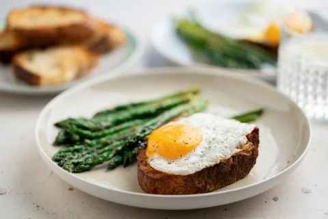 Fried eggs with toasted bread and green asparagus. Fast lunch ideas, healthy Stock Photos