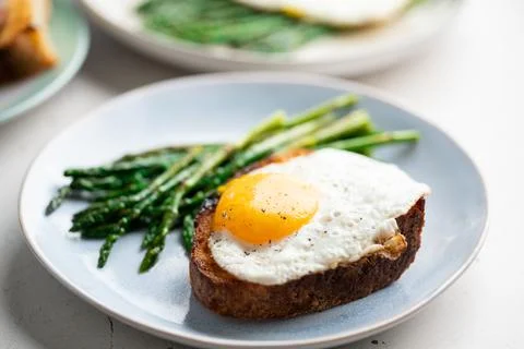 Fried eggs with toasted bread and green asparagus. Fast lunch ideas, healthy Stock Photos