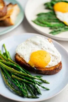 Fried eggs with toasted bread and green asparagus. Fast lunch ideas, healthy Stock Photos