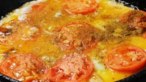 Fried eggs with tomatoes and onions in a frying pan. Medium shot. Stock Footage 285070538
