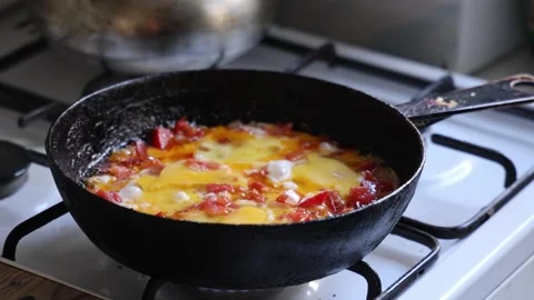 Fried eggs with tomatoes in a cast-iron kitchen garden Video stock 318243788