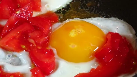 Fried eggs with tomatoes Stock Footage 134748700