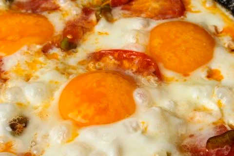 Fried eggs with tomatoes Stock Photos