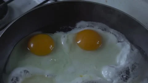 Fried eggs with two large yolks are fried in skillet for quick breakfast. Stock Footage 147744889