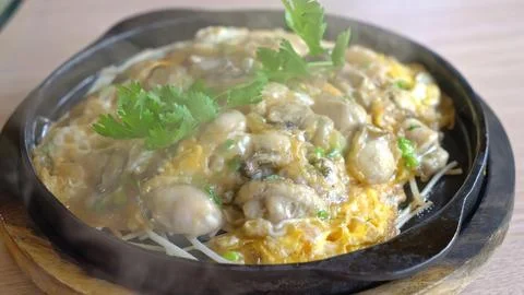 Fried eggs with vegetables cooking in a black skillet Stock Photos