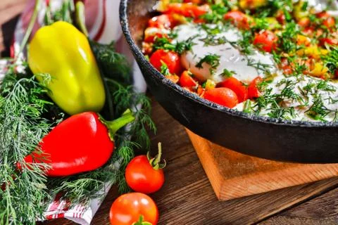 Fried eggs with vegetables in a pan Foto stock